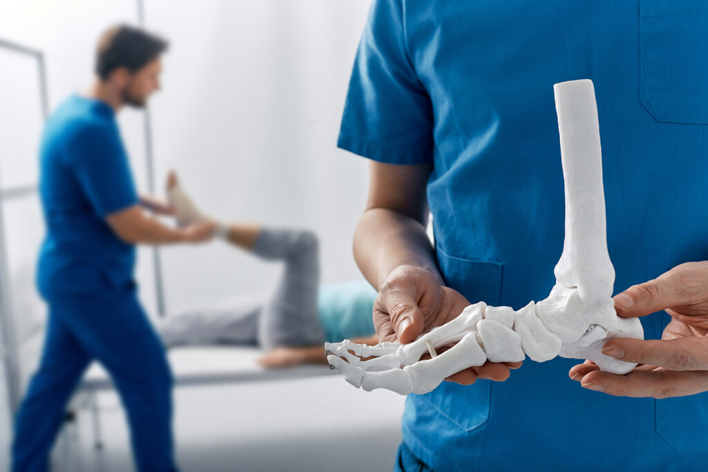 medico con in mano l'osso del piede